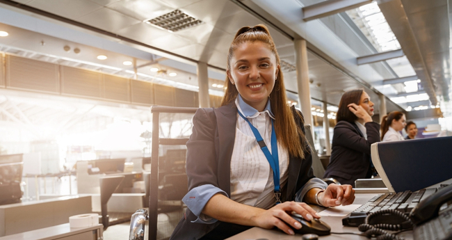 Woman at a helpdesk station in uniform, providing professional support services