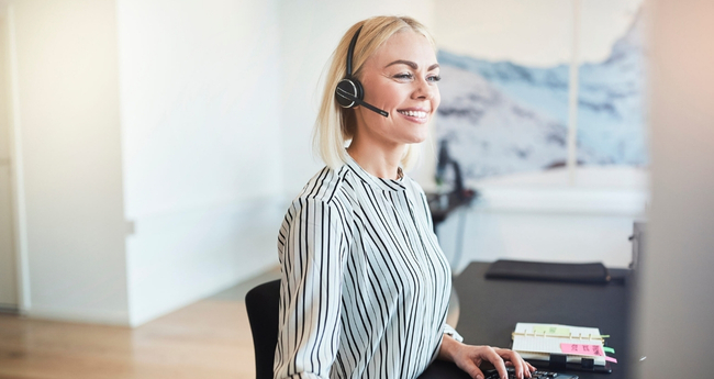 Woman wearing a headset, ready to assist customers in a professional IT support role