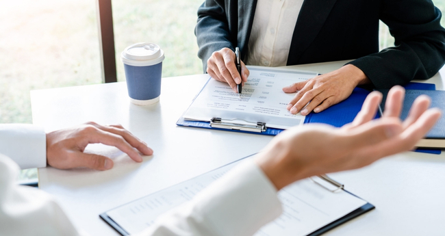 Close-up of hands and contract documents during a business agreement meeting