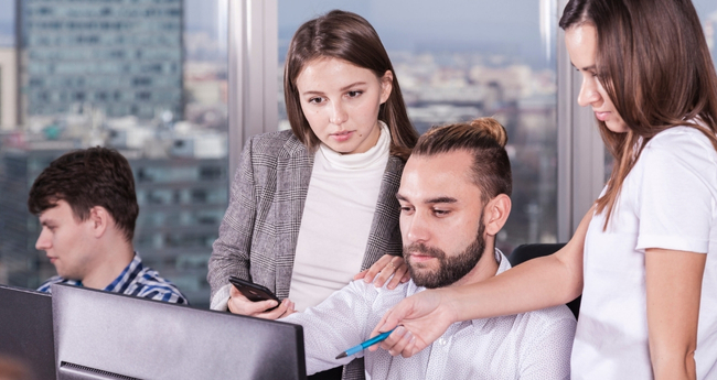 IT professionals collaborating in front of a screen, highlighting teamwork and knowledge sharing within Eccera’s digital solutions ecosystem