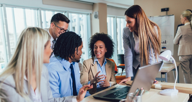 Group of professionals gathered around a screen, engaged in discussion, illustrating Eccera’s collaborative approach to tech and IT consulting