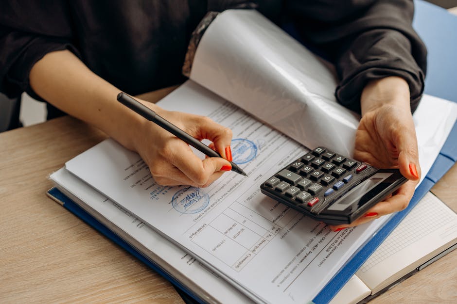 An accountant using a calculator and signing paperwork, showcasing financial analysis and compliance
